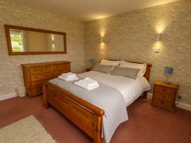 A bedroom with a bed and furniture at Campden in Rennington near Embleton