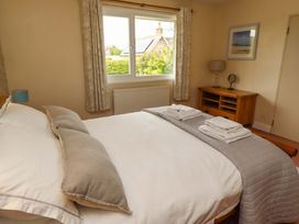 A bedroom with a bed and dresser at Campden in Rennington near Embleton