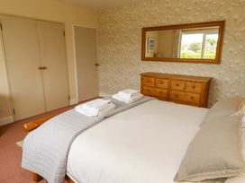 A bedroom with a bed and dresser at Campden in Rennington near Embleton