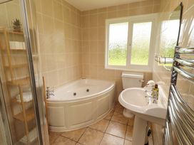 A bathroom with a bathtub, toilet, and sink at Campden in Rennington near Embleton