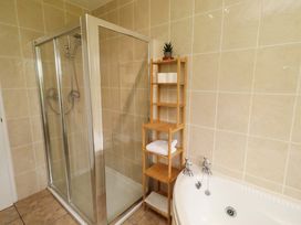 A bathroom with a shower and bathtub at Campden in Rennington near Embleton