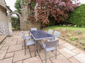 A garden with a dining table and chairs at Campden in Rennington near Embleton