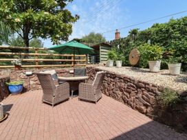 A garden with a table and chairs under an umbrella at Pete's Place in Taunton