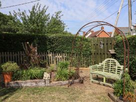 A garden with a bench and archway at Pete's Place Taunton