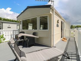 A deck area with a chair and table at Forest Retreat - FO26 in Saxmundham