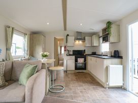 A kitchen with a sofa and dining area at Forest Retreat - FO26 Saxmundham