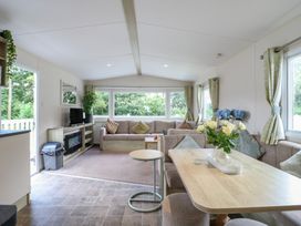 A living room with a sofa and television at Forest Retreat - FO26, Saxmundham