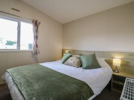 A bedroom with a bed and window at Forest Retreat - FO26 in Saxmundham