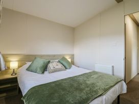 A bedroom with a bed and bedside lamps at Forest Retreat - FO26 in Saxmundham