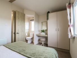 A bedroom with a bed and a wardrobe at Forest Retreat - FO26 Saxmundham