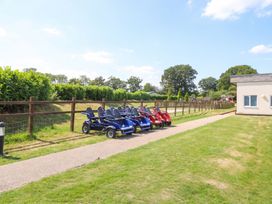 An outdoor area with go-karts parked along a pathway at Forest Retreat - FO26 Saxmundham