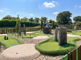 A mini golf course with sculptures and green putting greens at Forest Retreat - FO26 Saxmundham