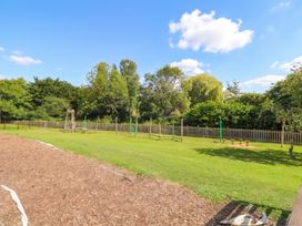 An outdoor area with playground equipment and grass at Forest Retreat - FO26 in Saxmundham
