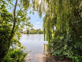 A view of a lake surrounded by trees at Forest Retreat - FO26 in Saxmundham