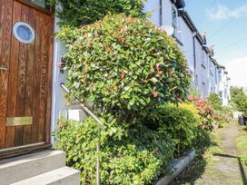 A front view of a house with a wooden door and shrubs at Dart Views in Dartmouth