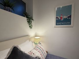 A bedroom with a bed, lamp, and poster at Dart Views in Dartmouth