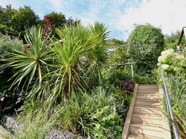 A garden with a wooden staircase and various plants at Dart Views in Dartmouth