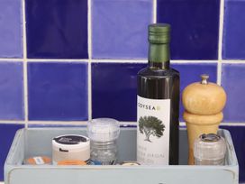 A kitchen storage box with various spices and olive oil at Dart Views in Dartmouth