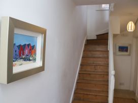A staircase with a framed painting in a hallway at Dart Views in Dartmouth