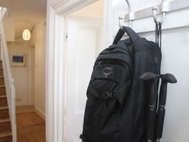 A hallway with a backpack and walking poles on a hook at Dart Views in Dartmouth