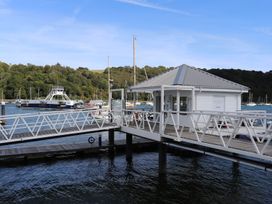 A dock with a boathouse and boats in the water at Dart Views in Dartmouth