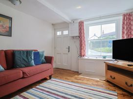 A living room with a sofa and television at Saybrook Cottage in Charmouth