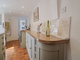 A kitchen with a counter and wine glasses at Saybrook Cottage in Charmouth