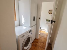 A laundry room featuring a washing machine and refrigerator at Saybrook Cottage in Charmouth