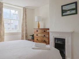 A bedroom with a bed and a lamp at Saybrook Cottage in Charmouth