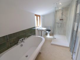 A bathroom with a bathtub, shower, toilet, and sink at Saybrook Cottage in Charmouth