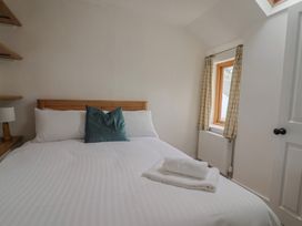 A bedroom with a bed and a window at Saybrook Cottage in Charmouth