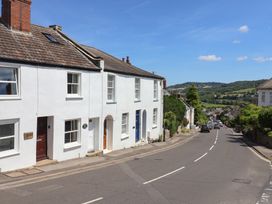 A street view with white houses and cars at Saybrook Cottage in Charmouth