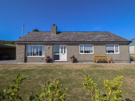 A bungalow with a garden and bench at Tyn Y Weirglodd Deiniolen