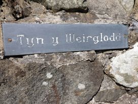 A sign on a stone wall at Tyn Y Weirglodd in Deiniolen