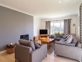 A living room with a coffee table and television at Tyn Y Weirglodd in Deiniolen