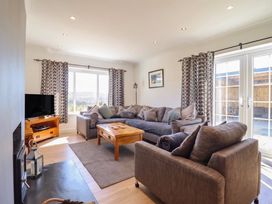 A living room with a sofa and coffee table at Tyn Y Weirglodd in Deiniolen