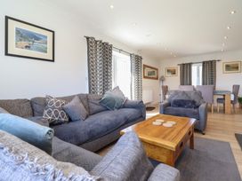 A living room with a sofa and table at Tyn Y Weirglodd in Deiniolen