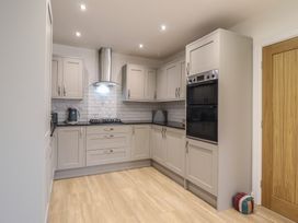 A kitchen with cabinets and appliances at Tyn Y Weirglodd in Deiniolen