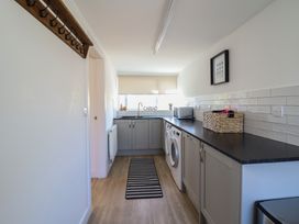 A utility room with a washing machine and microwave at Tyn Y Weirglodd in Deiniolen