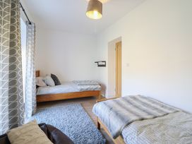 A bedroom with two beds and a rug at Tyn Y Weirglodd in Deiniolen