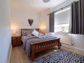 A bedroom with a bed and nightstand at Tyn Y Weirglodd in Deiniolen