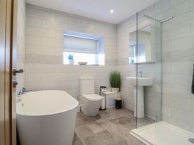 A bathroom with a bathtub, toilet, sink, and shower at Tyn Y Weirglodd in Deiniolen