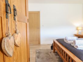 A bedroom with wooden furniture and heart decorations at Tyn Y Weirglodd in Deiniolen