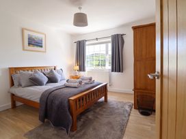 A bedroom with a bed and dresser at Tyn Y Weirglodd in Deiniolen