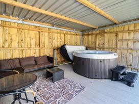 An outdoor area with a hot tub and seating at Tyn Y Weirglodd in Deiniolen