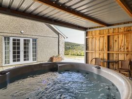 A hot tub with a sliding door and seating area at Tyn Y Weirglodd in Deiniolen