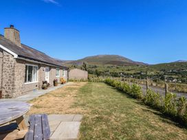 A house with a lawn and mountain view at Tyn Y Weirglodd in Deiniolen