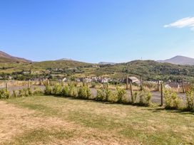 A view of houses and mountains with a grassy area at Tyn Y Weirglodd in Deiniolen