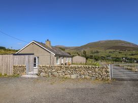 A house with a stone wall and a gate at Tyn Y Weirglodd in Deiniolen