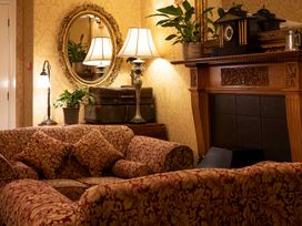 A living room with a sofa and lamp at Lonsdale House Bowness-On-Windermere